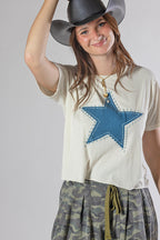 A woman wearing a Roger-Cowboy-Straw-Hat-Black, a cream-colored short-sleeve crop star top, and camouflage pants-FleaStyle