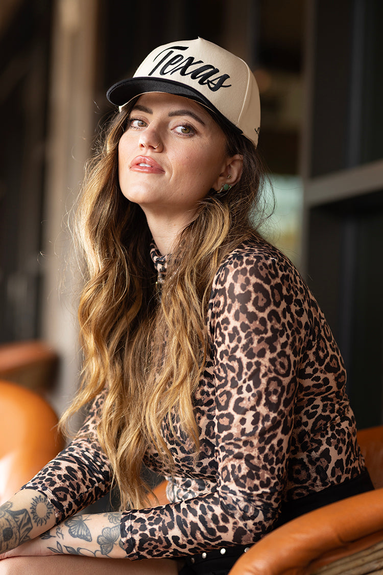 Woman wearing a leopard print mesh top and black  'Texas' trucker hat-FleaStyle